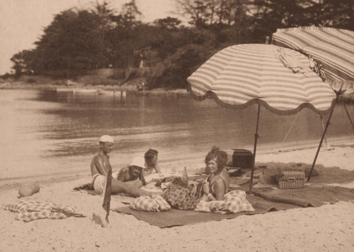 Une famille installée sous un parasol sur la plage de La Garoupe au début des années 1920