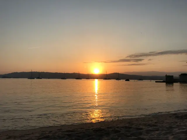 Soleil orange à l’horizon reflété dans une mer calme